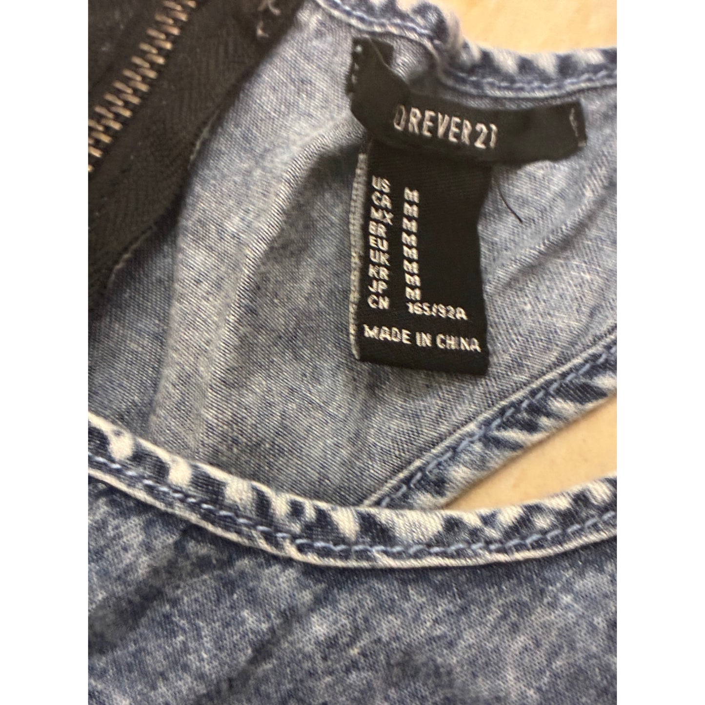 Forever 21 denim romper features a distinct exposed back zipper